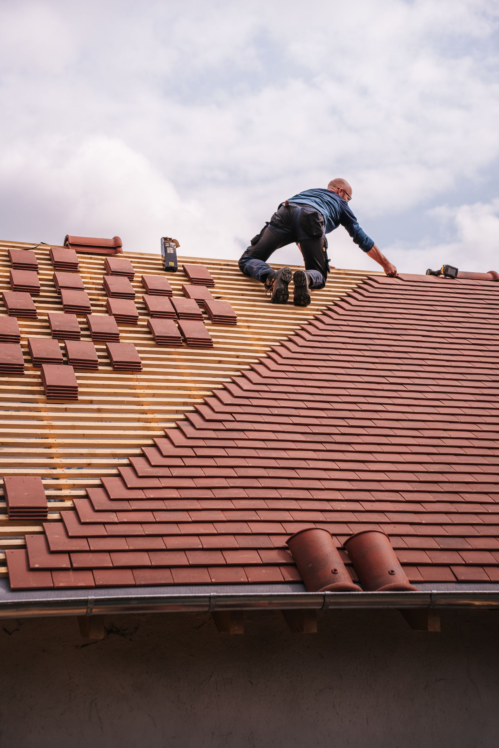 Northgate roofer laying plain tiles on roof battens
