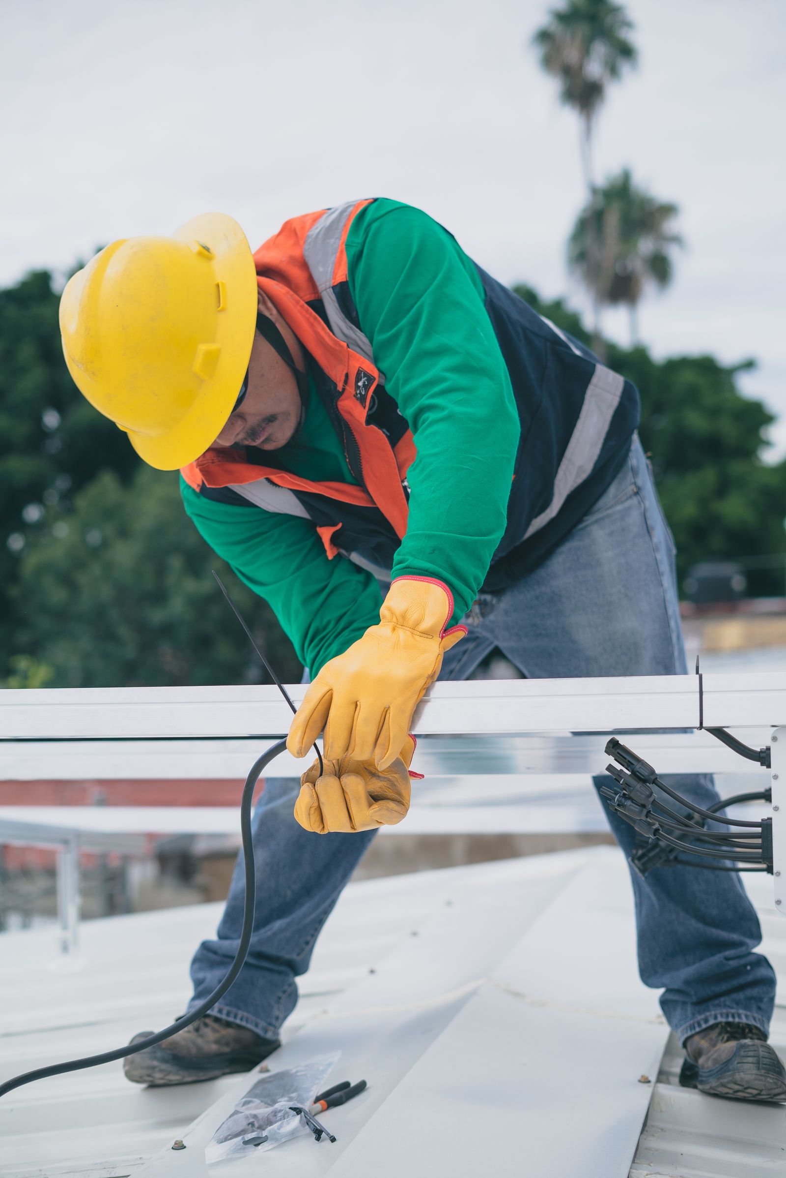 Technician in safety gear servicing rooftop equipment