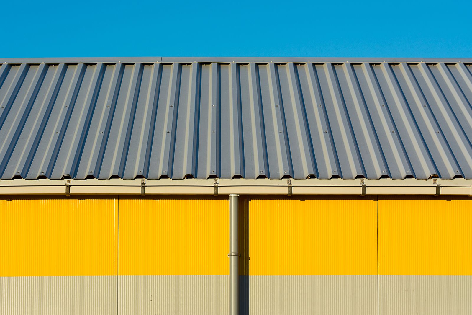 Modern corrugated metal roof under a clear sky